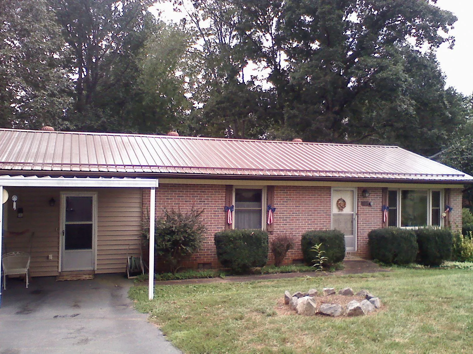 Bronze metal roof and carport on a brick ranch home — Roof Repair work by our crew in Smyrna